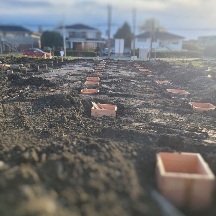 Footing forms laid out across a building lot at dusk