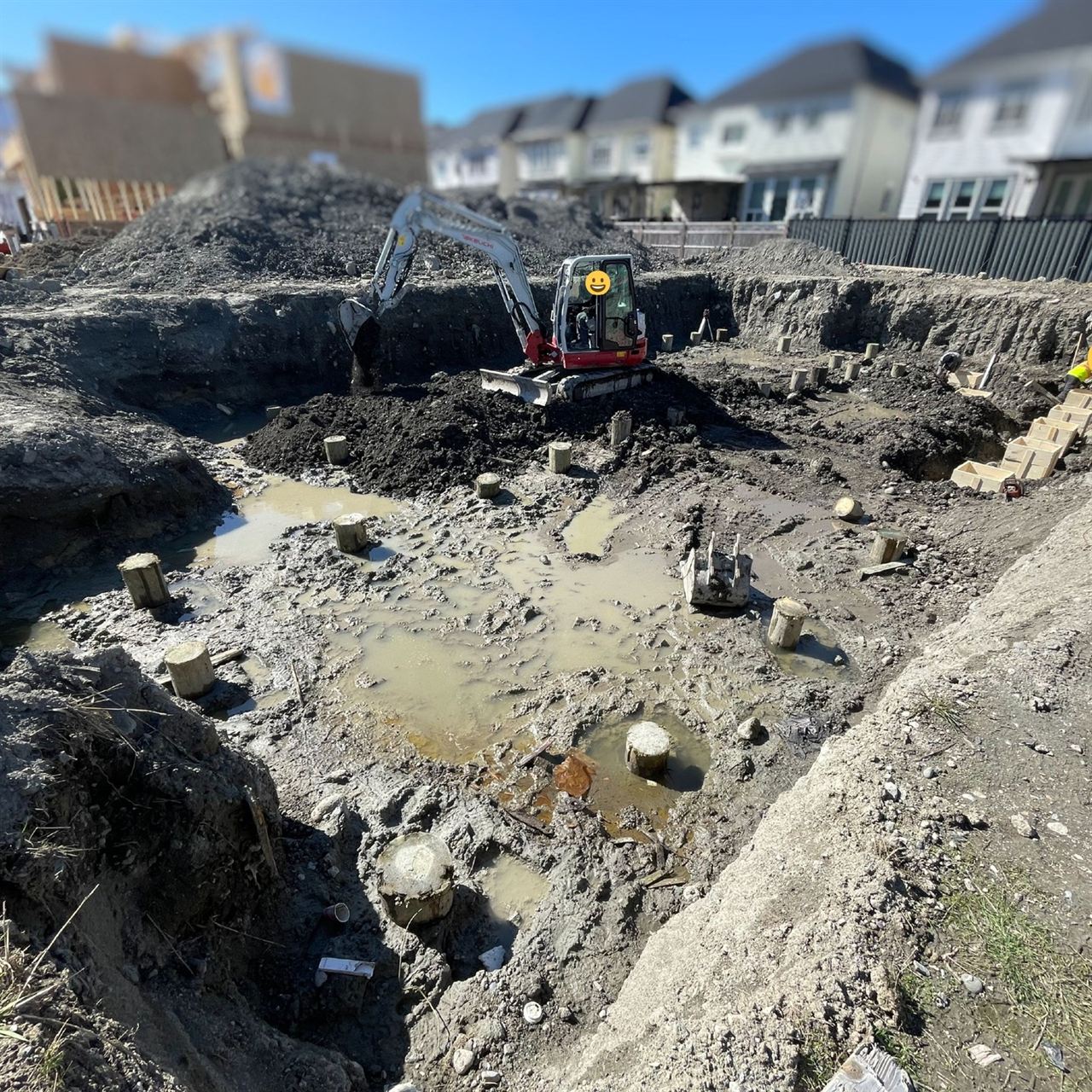 Foundation backfill — skid steer and excavator on site