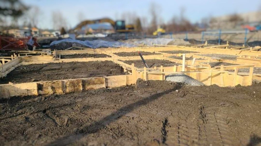 Footing backfill across a large site at sunset