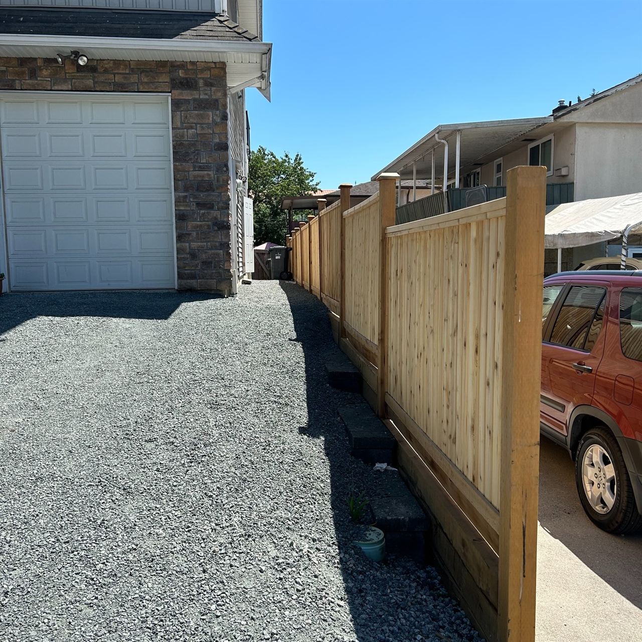 Cedar fence running along a gravel driveway